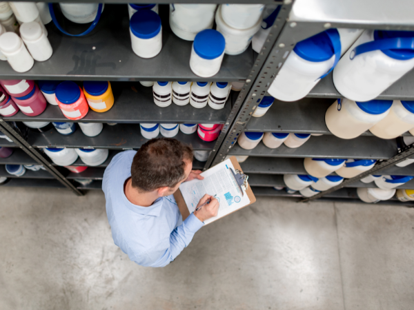 image depicting a warehouse worker with chemical inventory using manual paper processes, which are inefficient