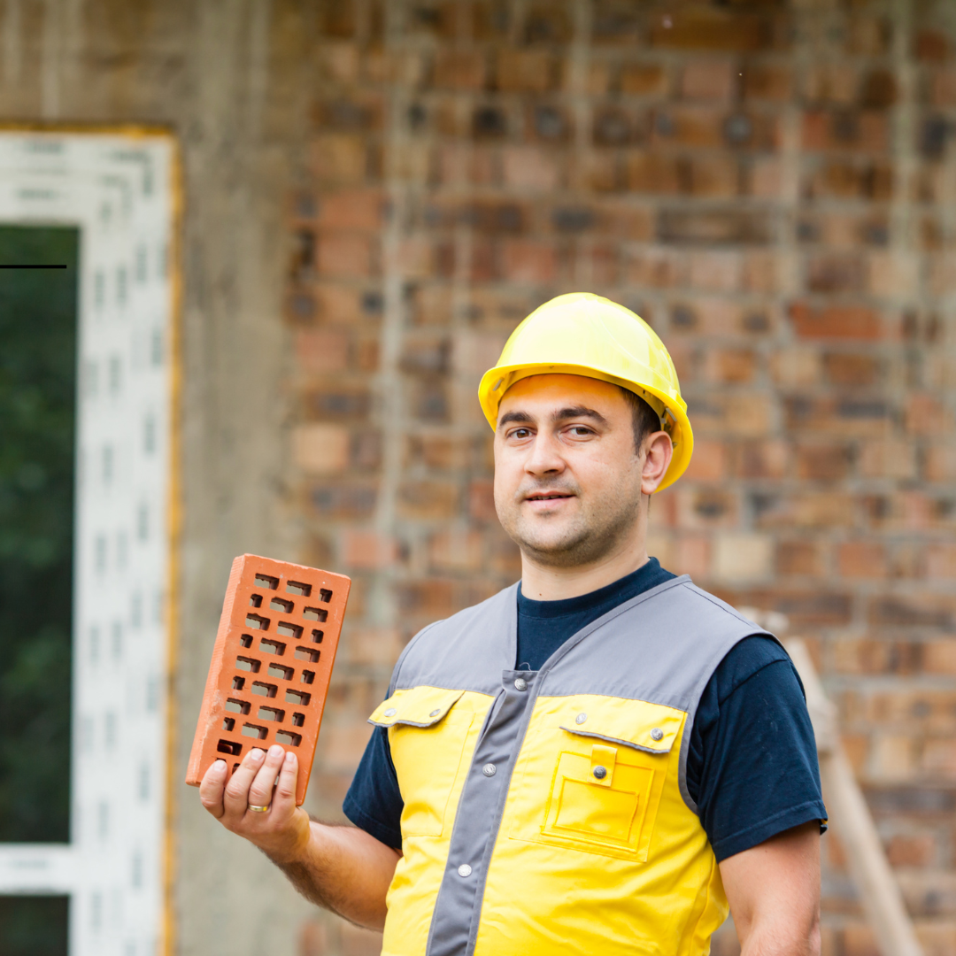 A man holding a brick in the construction supply chain industry.  